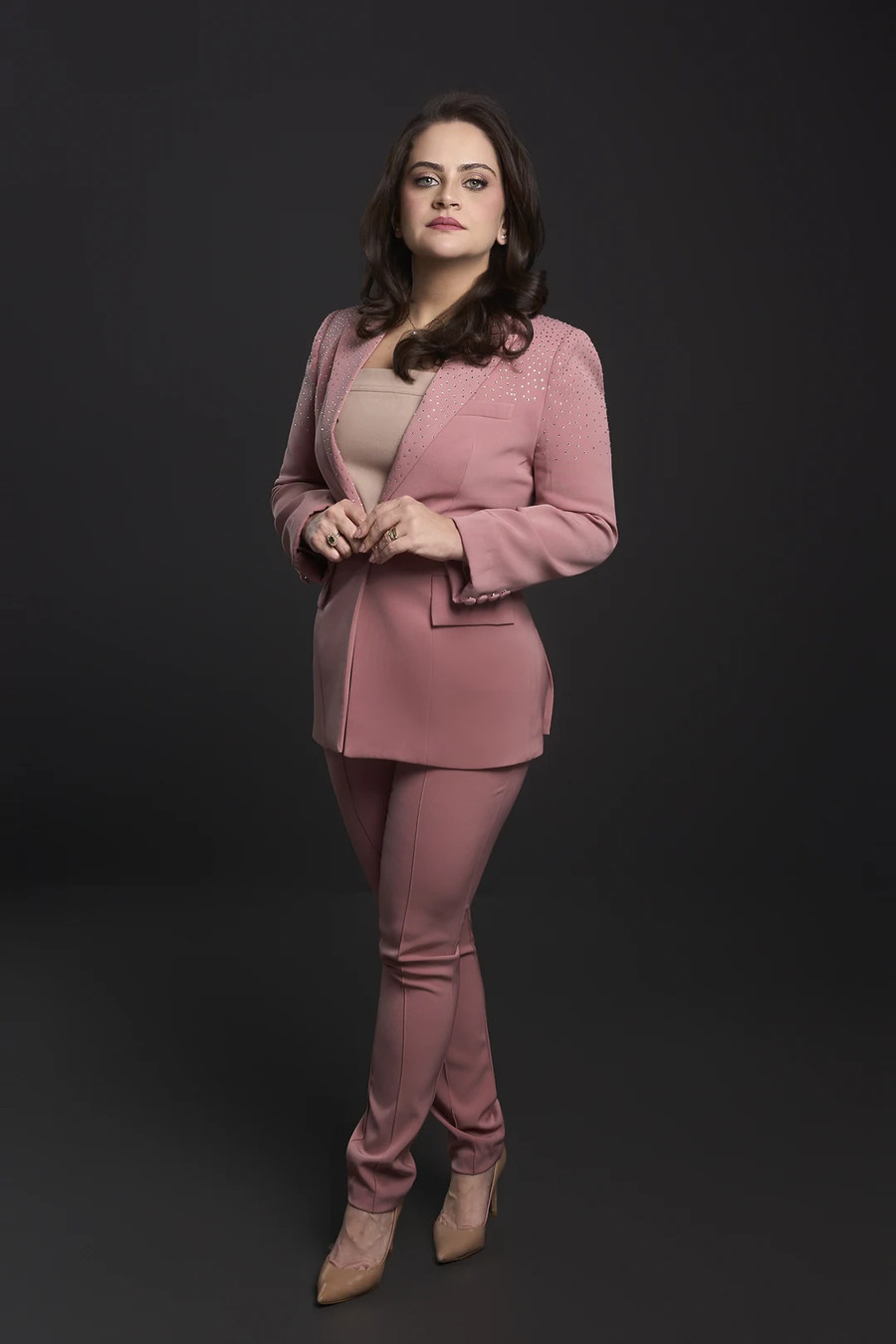 Dra. Claryssa Nascimento em traje rosa, retrato de estúdio de corpo inteiro